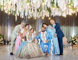 Husband and wife with family members posing for a portrait