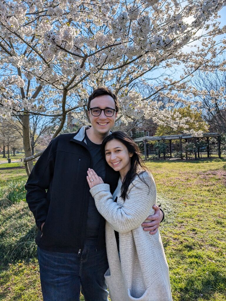 Thursday, March 21st, Josh gets a call that the custom engagement ring he designed is ready. He picks it up but can't wait to propose, so he takes Julia on a walk to a nearby garden. She says yes! And by chance, their neighbor walks by, who takes this amazing picture for them.