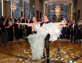 Groom lifting bride during first dance at wedding reception