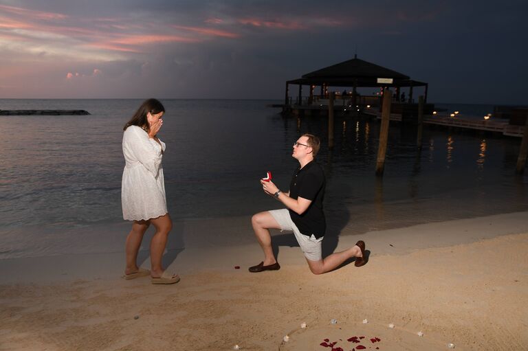 As they were coming to the end of the photoshoot and nearing their dinner table, Emily noticed a heart of rose petals and tealights on the sand, and when she turned around, Nathan was down on one knee!
