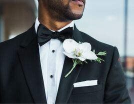 groom wearing black suit with white wedding pocket square