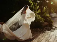 Bride walking with long veil and dress train