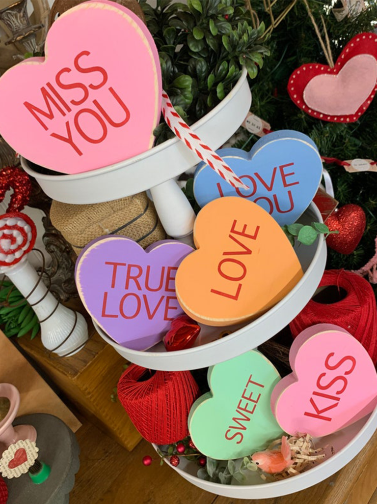 Colorful wooden conversation hearts with phrases like 'Miss you,' 'True love,' etc.