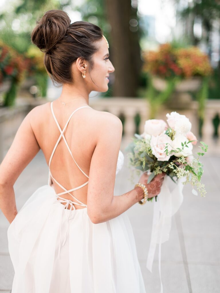 Bride wears her hair in an elegant top knot. 