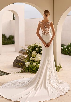 Mermaid silhouette wedding dress with deep neckline and straps. Illusion back with skirt in stretch crepe and beaded lace.