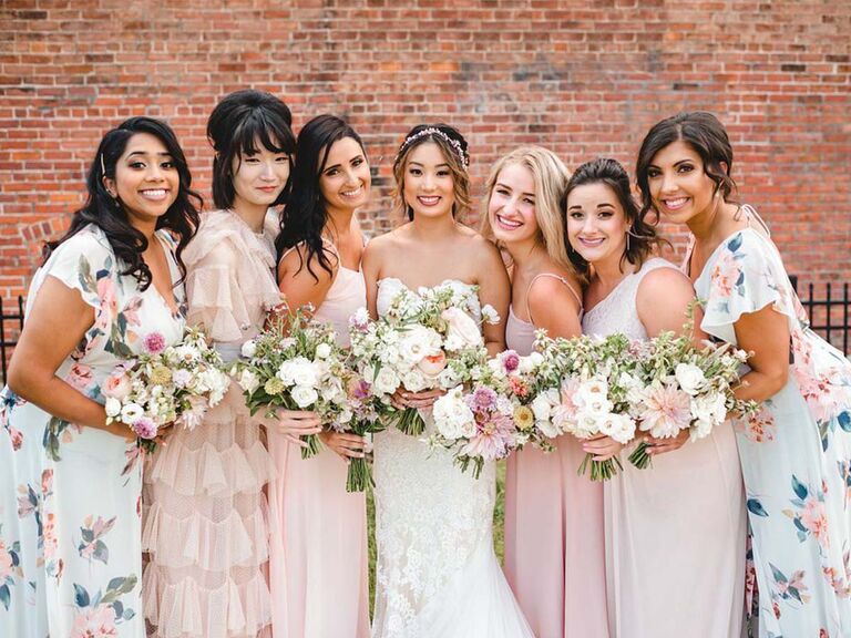 bride with her bridesmaids wearing pink and floral dresses
