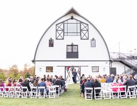 Couple exchanging their vows beside the large white barn venue at Sweeney Barn