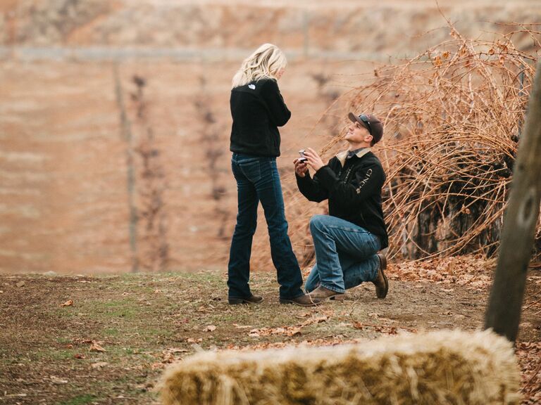 Man proposing to woman in hayfield during the fall