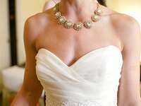 A bride shows off her necklace on her wedding day