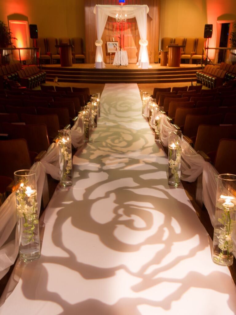 Beautiful lighting projects a rose-print onto the ceremony aisle. 