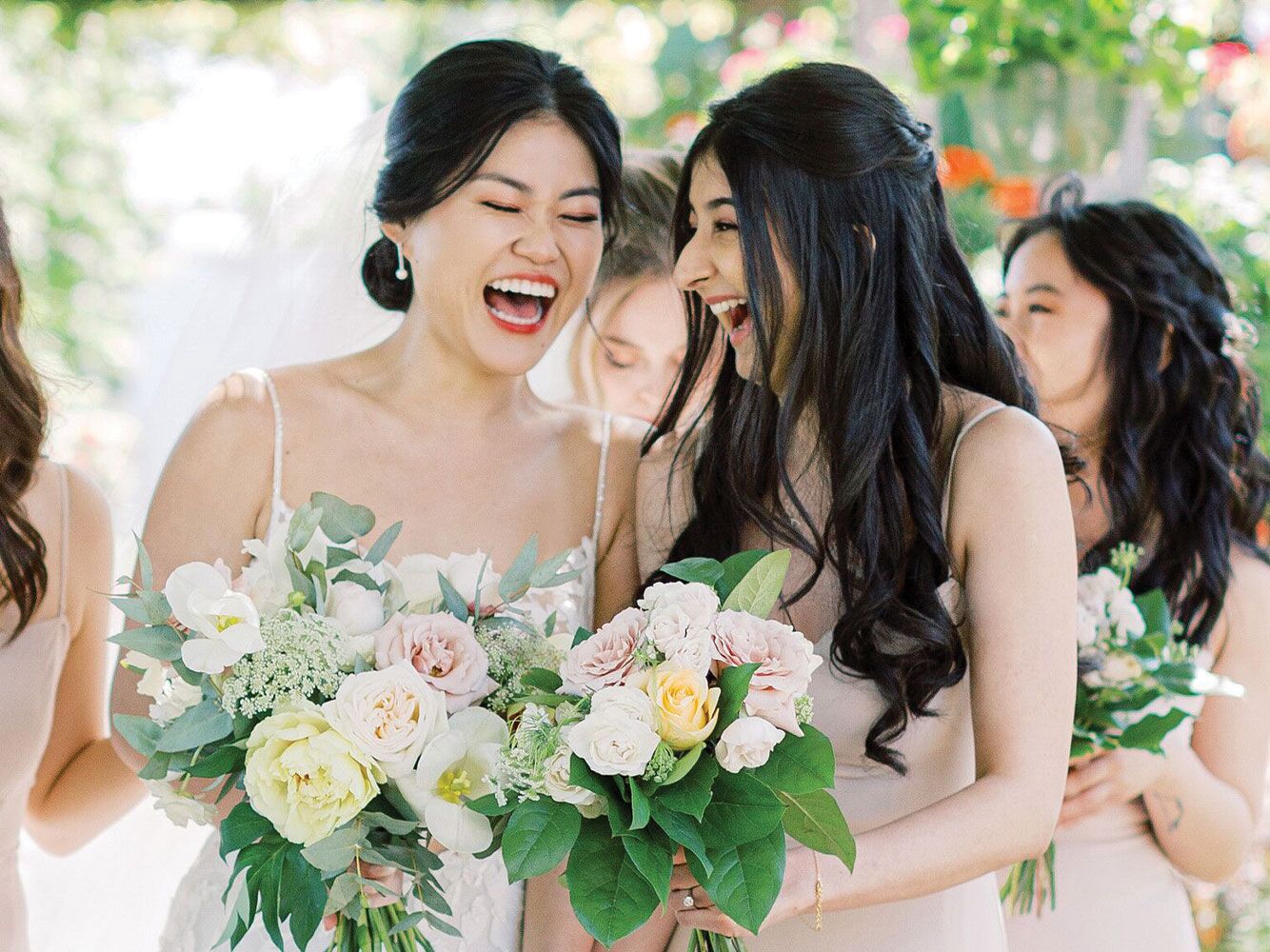 Bride and maid of honor laughing with each other