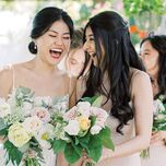 Bride and maid of honor laughing with each other