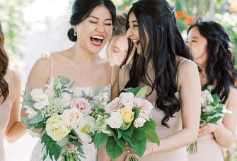 Bride and maid of honor laughing with each other