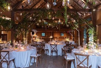 Inside beautiful barn venue with hanging foliage and light fixtures