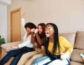 Group of women cheering on the couch