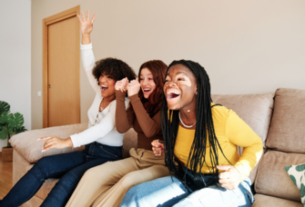 Group of women cheering on the couch