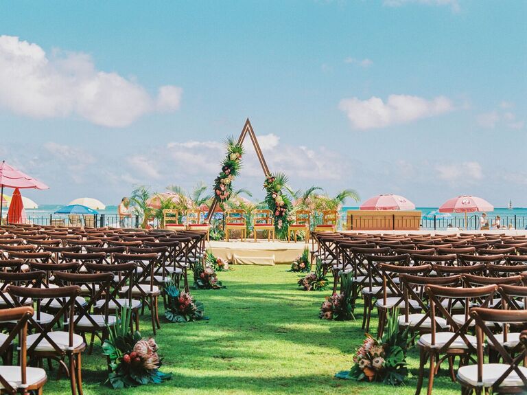 Tropical ceremony setup with wood triangle arch