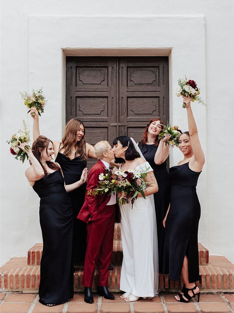 Couple surrounded by bridesmaids in black dresses