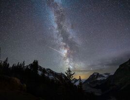 A night sky with the Milky way and shooting star over mountains at Peyto Lake, Banff national park, Alberta, Canada