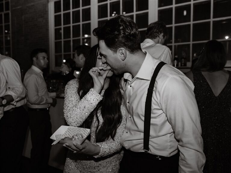 Jamie Milne feeding husband Brandon dessert at their wedding reception