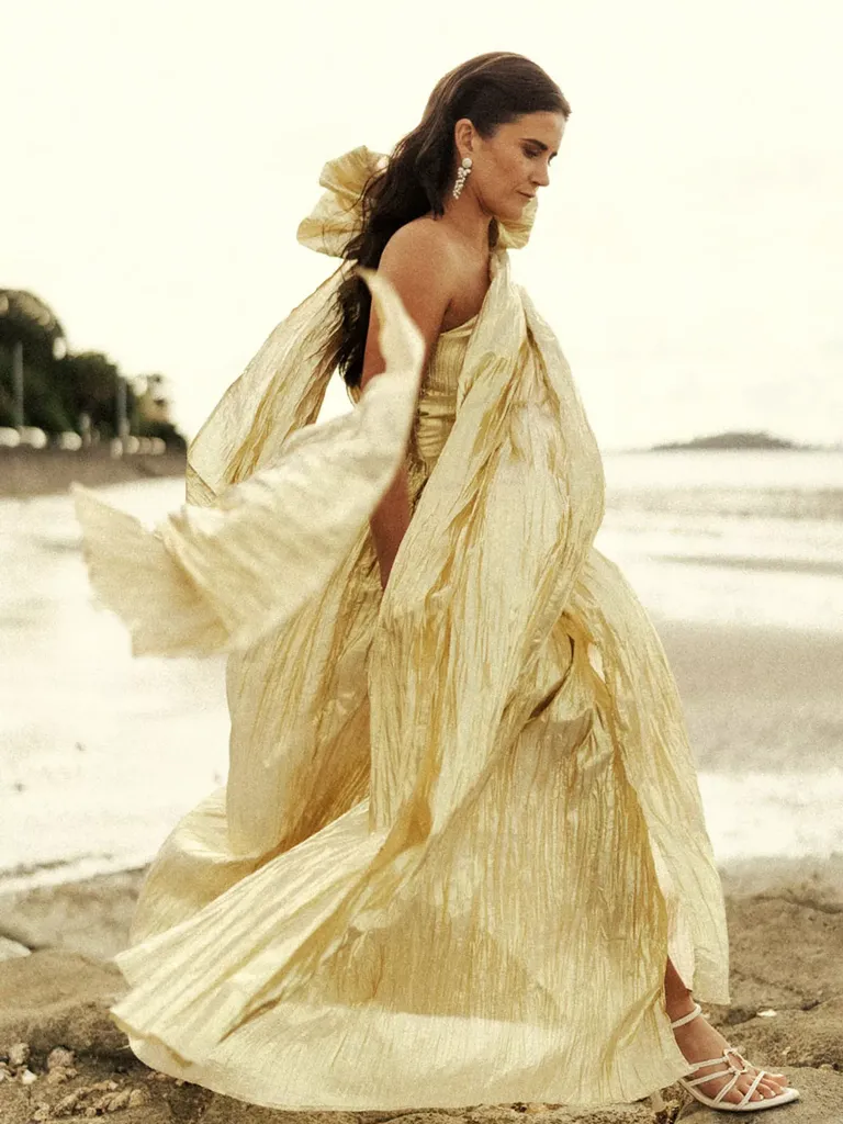 Bride in Flowing Gold Metallic Gown and Down Hairstyle on Rocky Beach