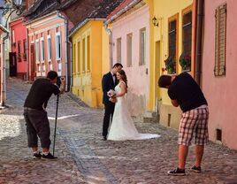 two wedding photographers shoot couples wedding portraits in colorful street