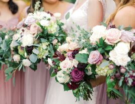 bride and bridesmaids holding purple wedding bouquets with ivory roses, light purple roses, pink roses and eucalyptus