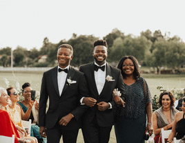 Groom and groom's parents walking down the aisle