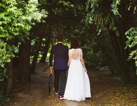 Bride and groom walking through forest