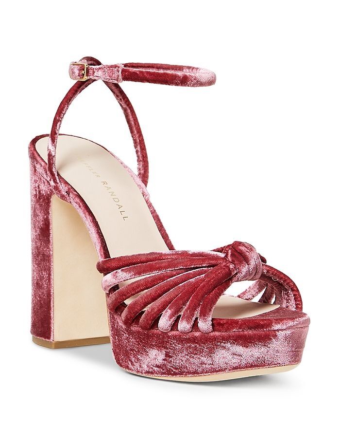 Velvet pink high-heeled sandals with an open toe and an ankle strap. 