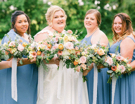 Bride and bridesmaids pose for a group photo.