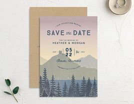 Mountain landscape with sunset background, with 'Save the Date' in bold blue type