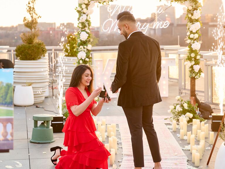 Woman proposing to boyfriend on rooftop