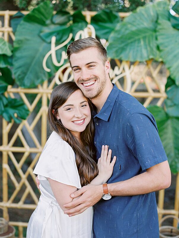 couple in front of engagement party backdrop