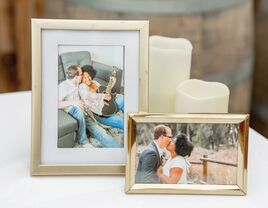 Couples engagement photos in gold frame on table