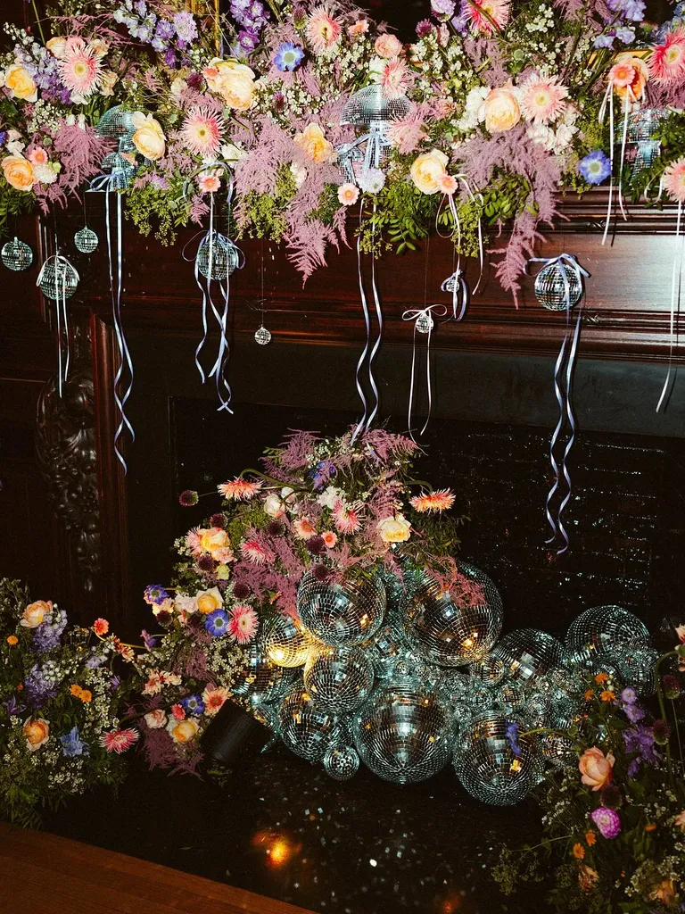 Fireplace disco ball and floral installation, taylor swift themed wedding 