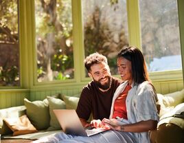 Couple looking at their online wedding registry on a laptop