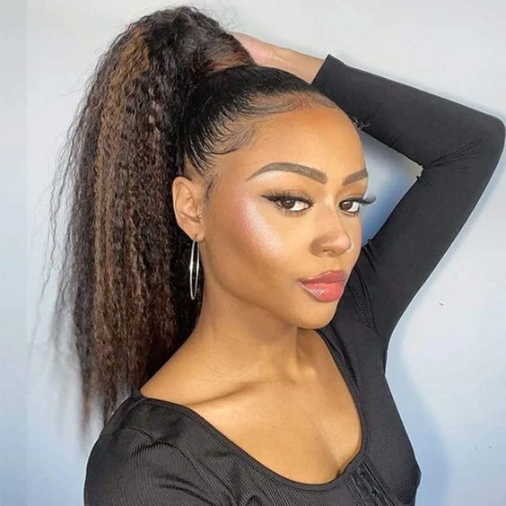 High ponytail wedding guest hairstyle with natural curls