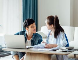 Young couple wedding planning on laptop at home