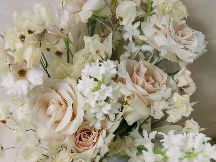 A wedding bouquet with beige roses and white hyacinth flowers