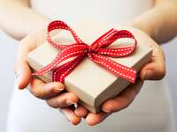 person holding a gift with red ribbon