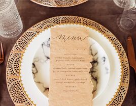 Distressed menu card on marble plate iwth gold edge