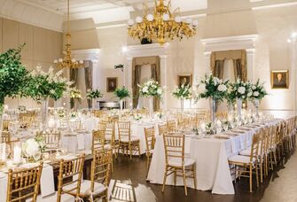 Inside luxurious rehearsal space with gold Chivari chairs and florals