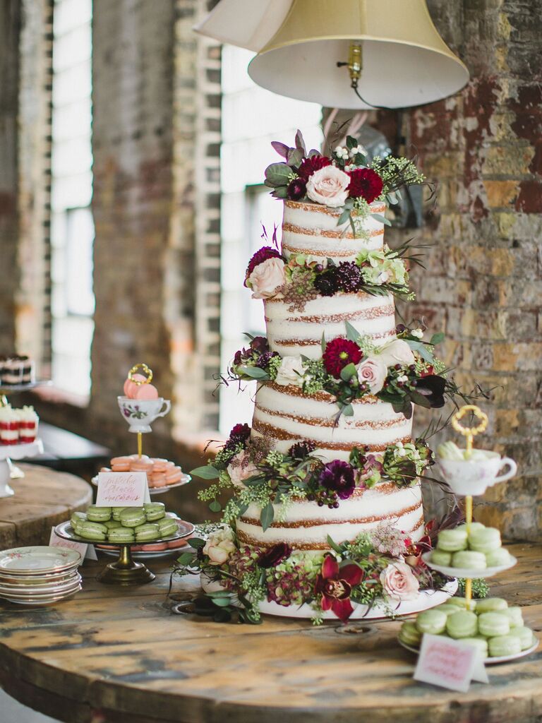 unique four tier wedding cake with tilted tiers and flowers in between each tier