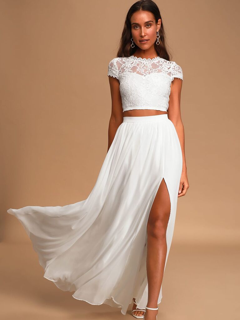 Model wears a white two-piece skirt and crop top set. 