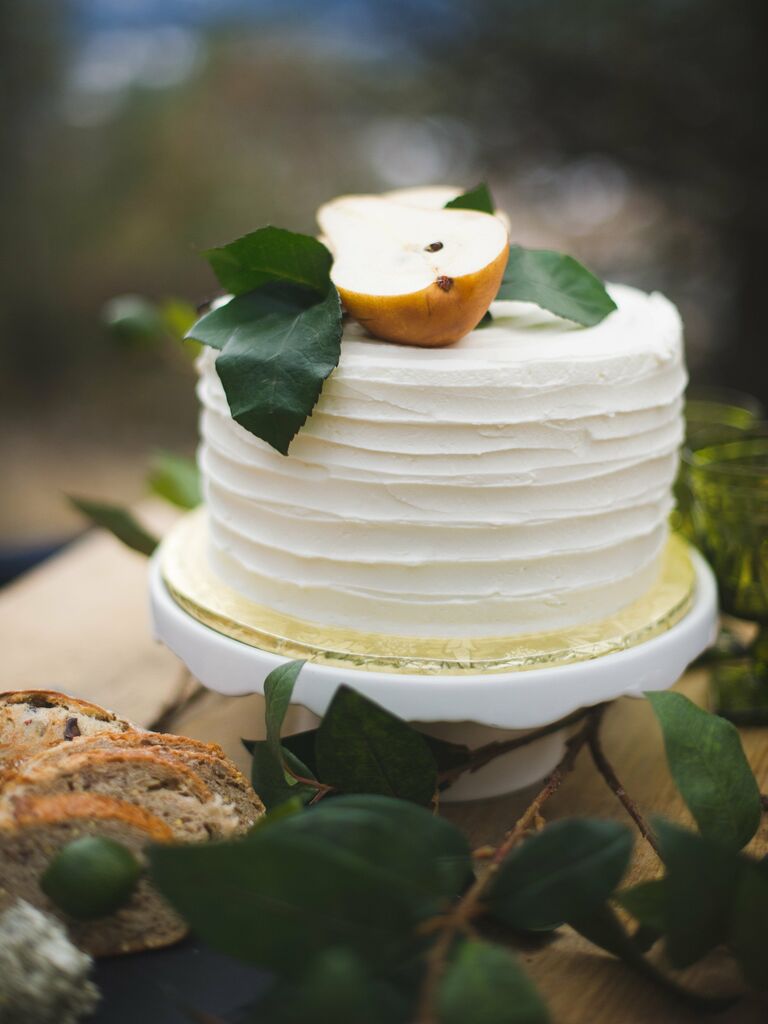 simple buttercream wedding cake decorated with textured icing and sliced pear on top 