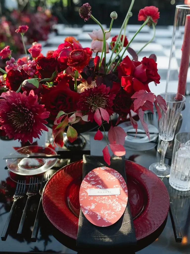 Red-and-Black Place Setting With Red Menu, Charger and Centerpiece, Black Linen and Flatware