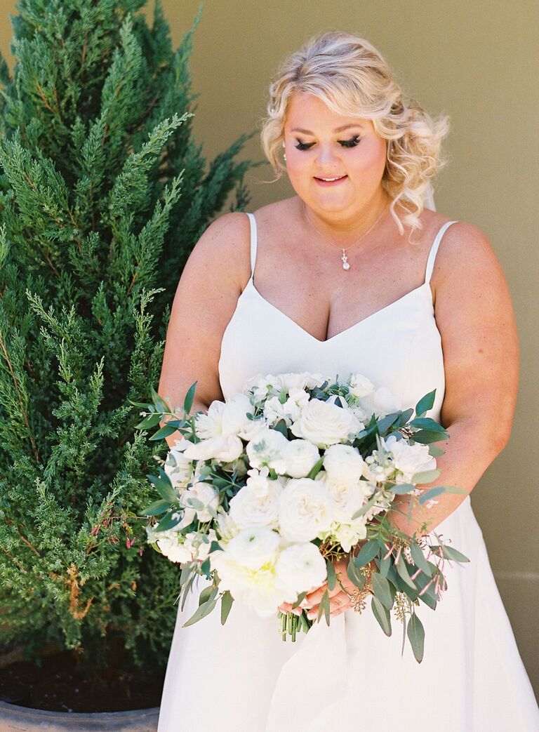 Bride holding white bouquet with eucalyptus
