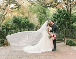 Groom with bride on wedding day wearing cascading cathedral-length veil