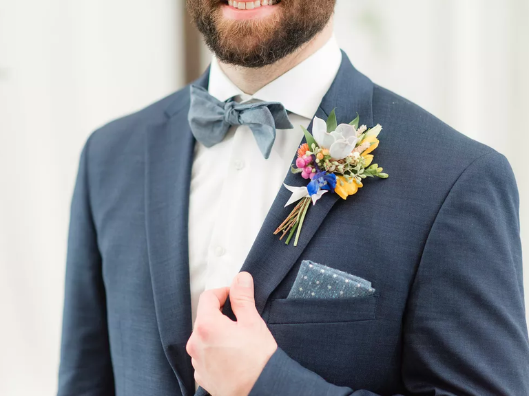 Lovely grey-blue suit with colorful corsage